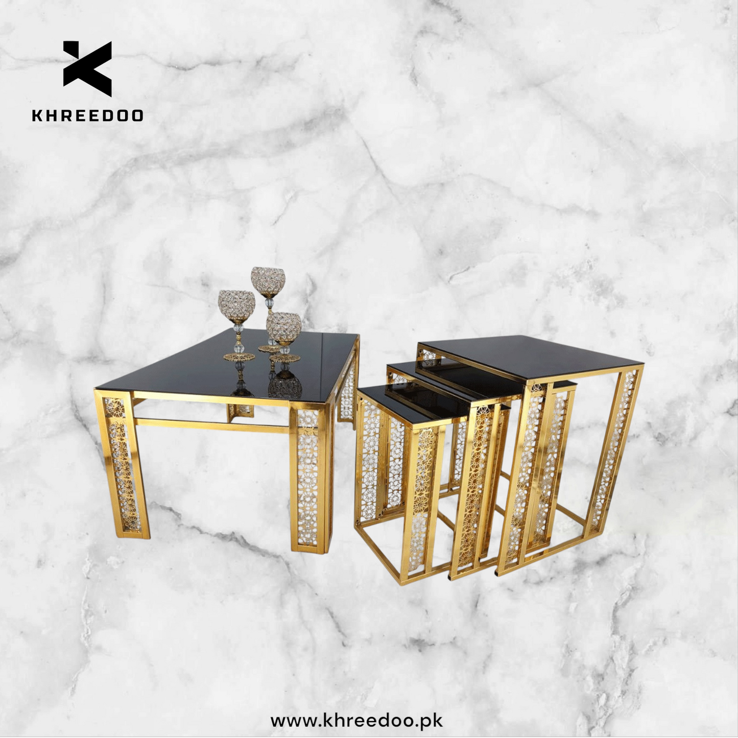 A set of three nesting tables with a gold metal frame and wooden marble texture top, displayed against a marble background.
