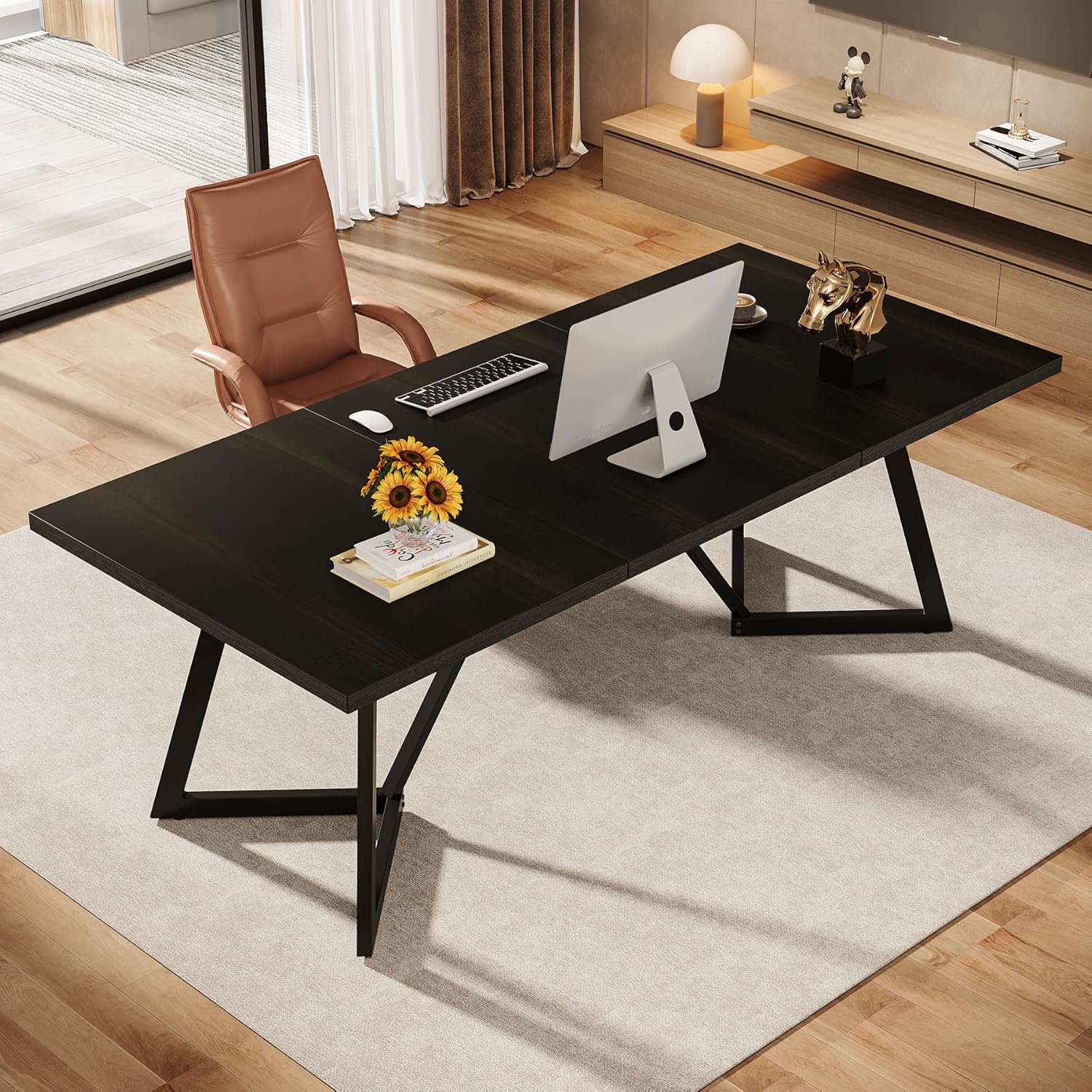 Modern office desk with computer setup in a room with wooden flooring and a chair.