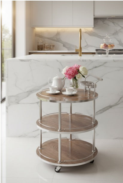 Three-tiered wooden serving cart with tea set and flowers in a modern kitchen.
