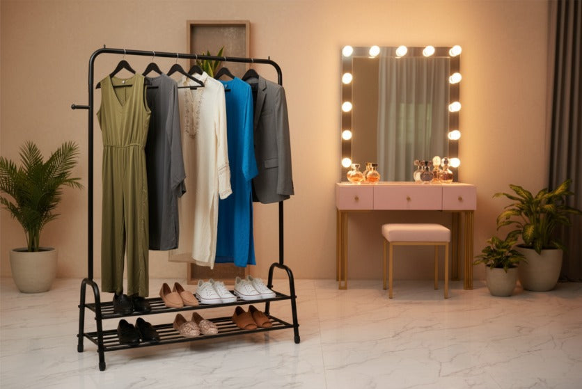 Clothing rack with dresses and shoes in a room with a vanity mirror and plants.