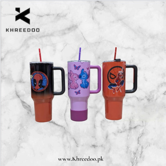 Three handled insulated tumblers with straws are shown on a white marble background. The left tumbler is black at the top fading to orange at the bottom with a Spider-Man graphic.